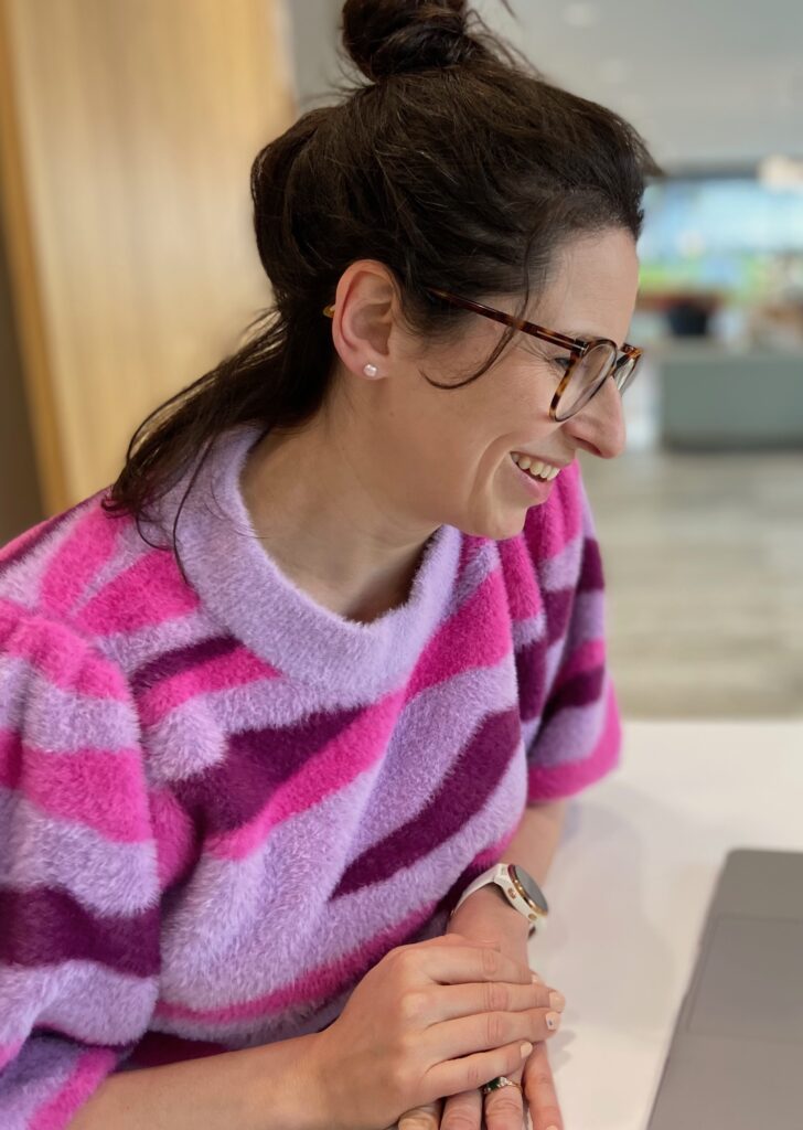 Angela M Solomon looks down at a laptop, in a professional setting