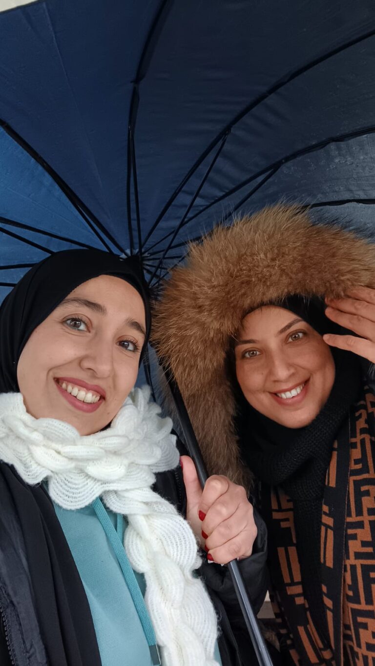 AMS team member Loria smiling at the camera from under a fluffy hood